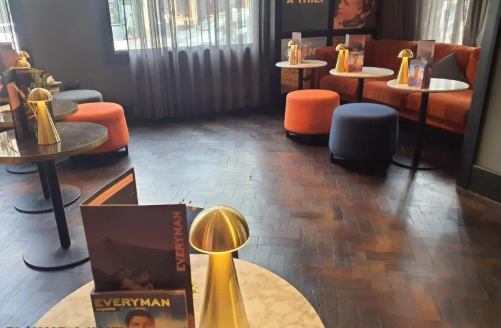 Everyman Cinema Bristol - showing the new lights installed by Medlec, a sofa, wooden flooring and orange and blue cusions with tables and the new lights