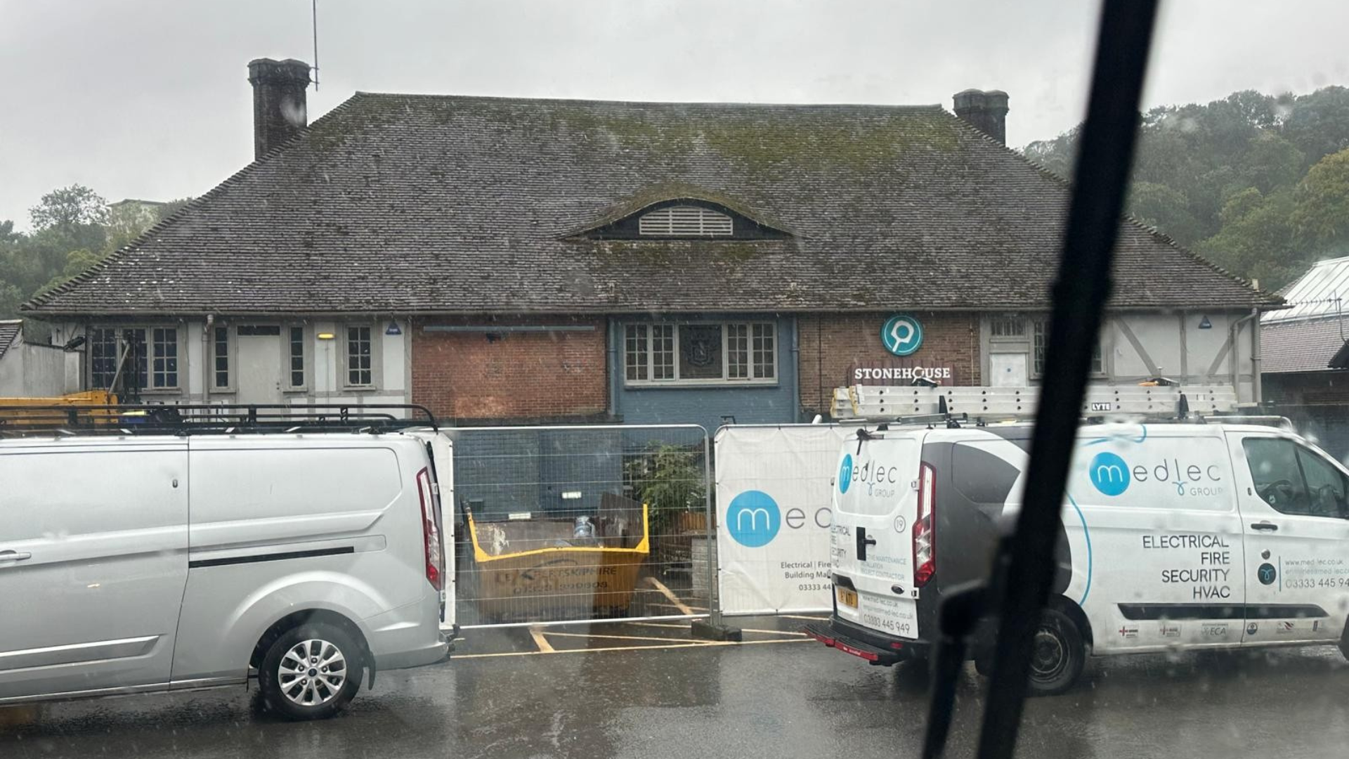 Image of a hospitality venue having building work done, with a skip outside, and a Medlec Group van