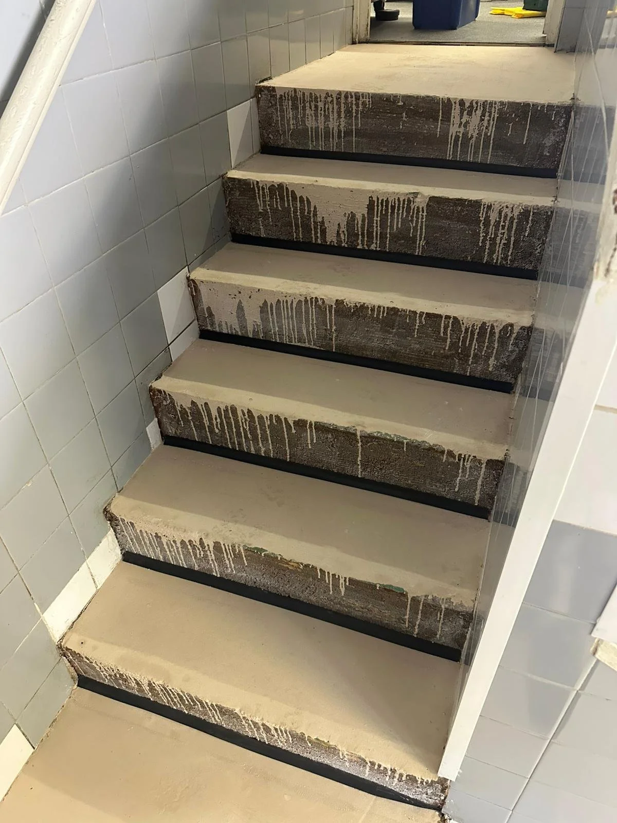 Preparring the stairs with safety adhesive for Altro Stronghold flooring