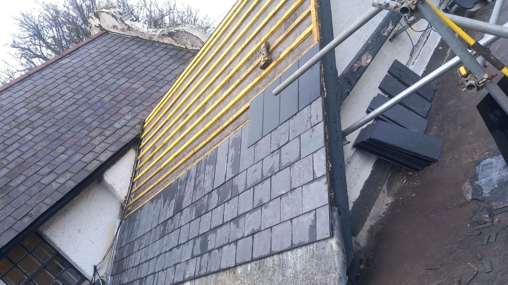 New roof being installed on a Surrey roof showing slade tiles and dry ridge system being installed