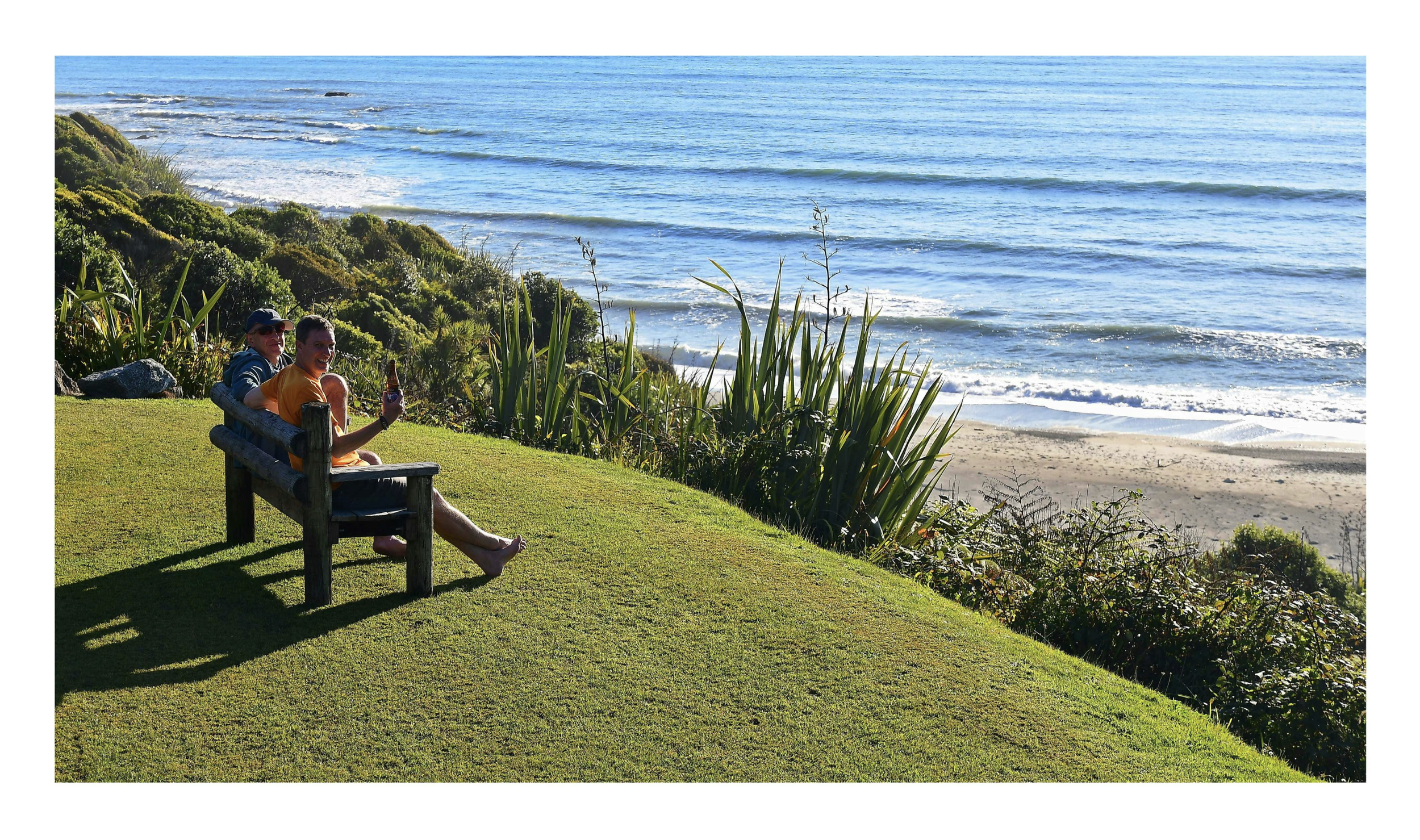 Guests enjoying time out and a beer with views to sea from lookout seat at Breakers Boutique Accommodation
