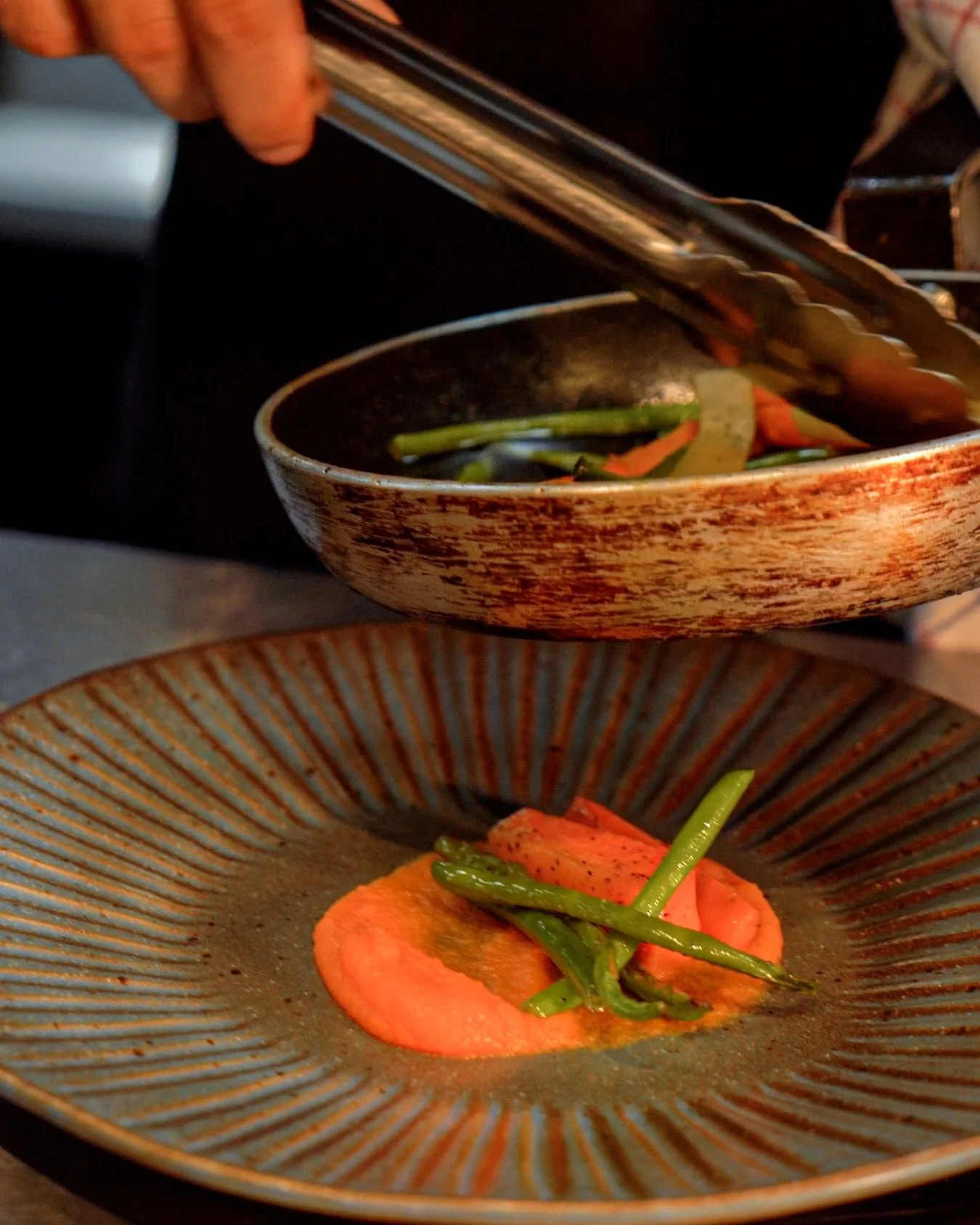 Watching the plating is half the experience.
This is the part where you go: okay&hellip; this is going to be good.

What do you think is going to be placed after the veggies?