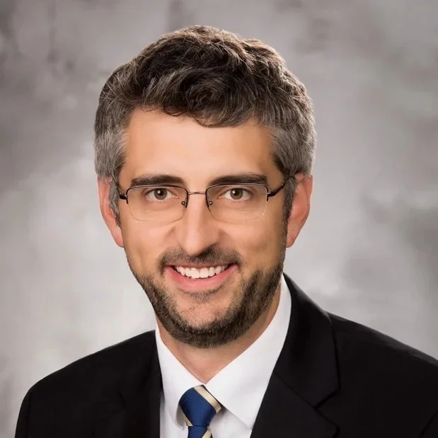 A professional headshot of Dr. Daniel Flewelling.