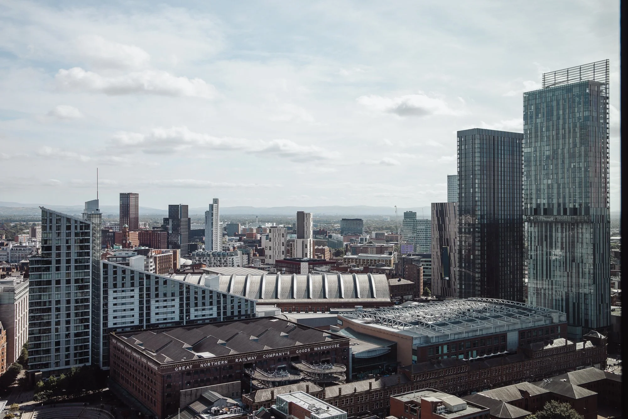 Manchester cityscape with modern skyscrapers, historic buildings, and the Great Northern Railway Company's warehouse.