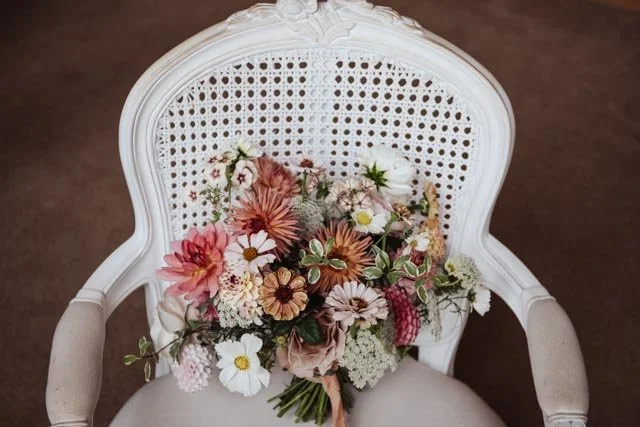 Bouquet of mixed flowers on white wicker chair