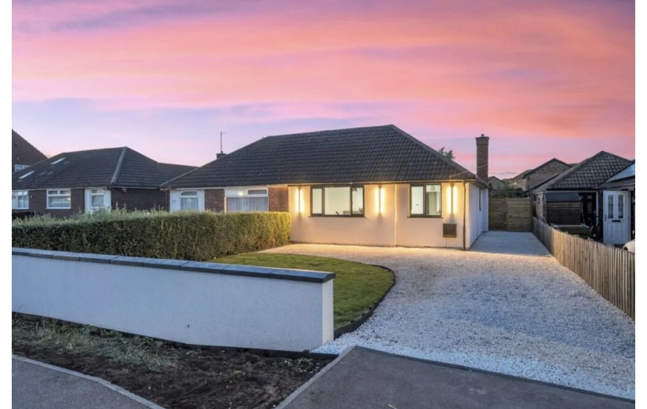 Photo of a partially demolished kitchen attached to a house, with exposed insulation and construction debris on the ground.