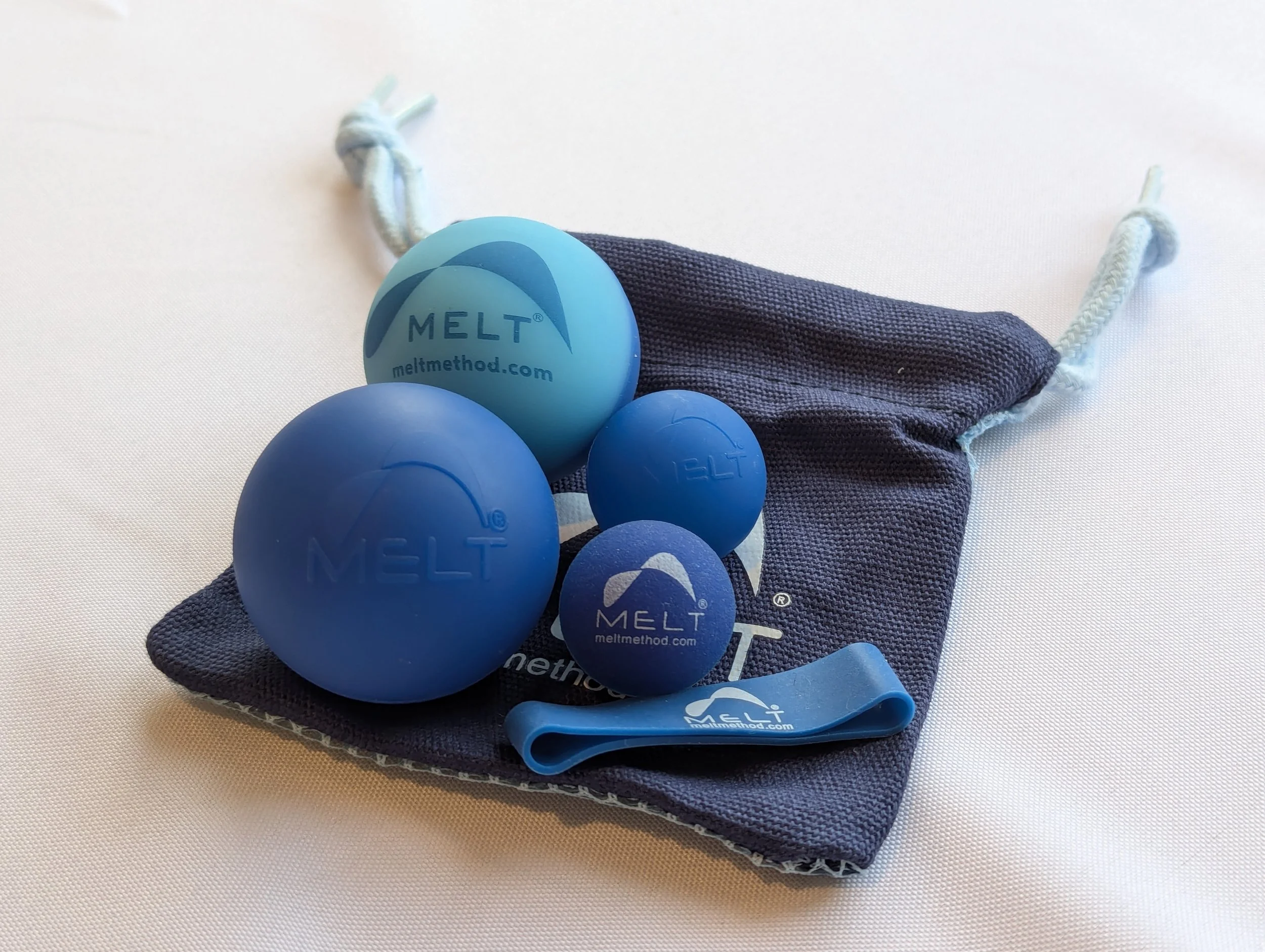 Melt balls and band resting atop the melt branded pouch