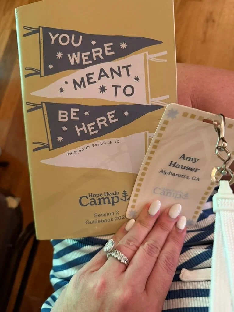 Hope Heals Camp guidebook and Amy Hauser's camp name badge.