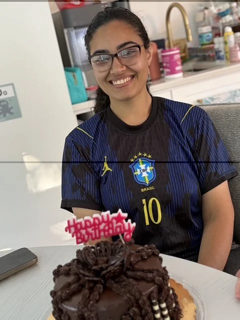 Au pair Fernanda smiling in a Brazil jersey next to her birthday cake