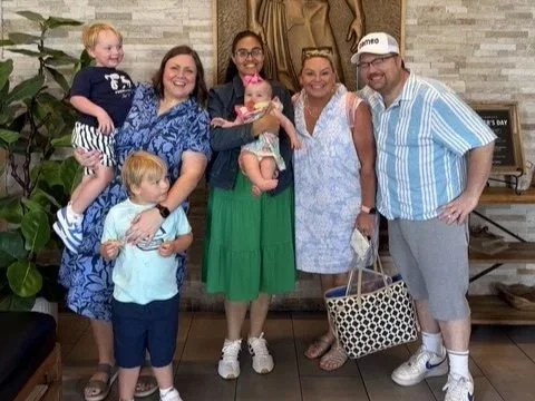 Au pair Fernanda with the family and grandparents posing in a hotel lobby
