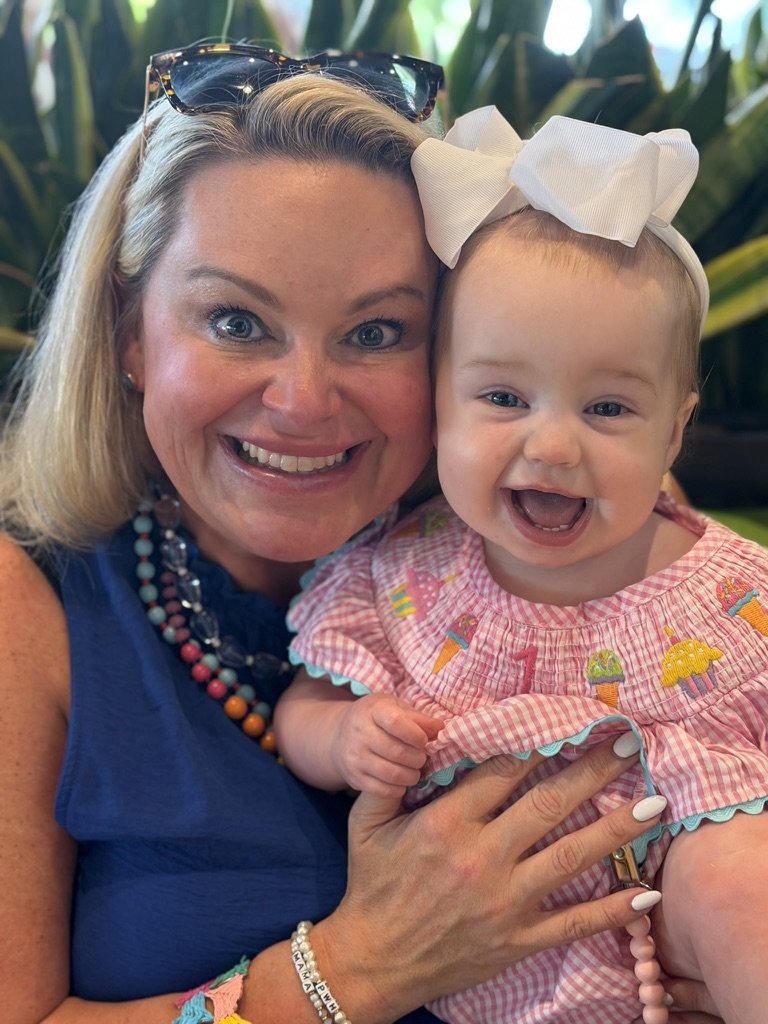 Amy Boland Hauser smiling cheek to cheek with her daughter Isla Grace in an ice cream print outfit