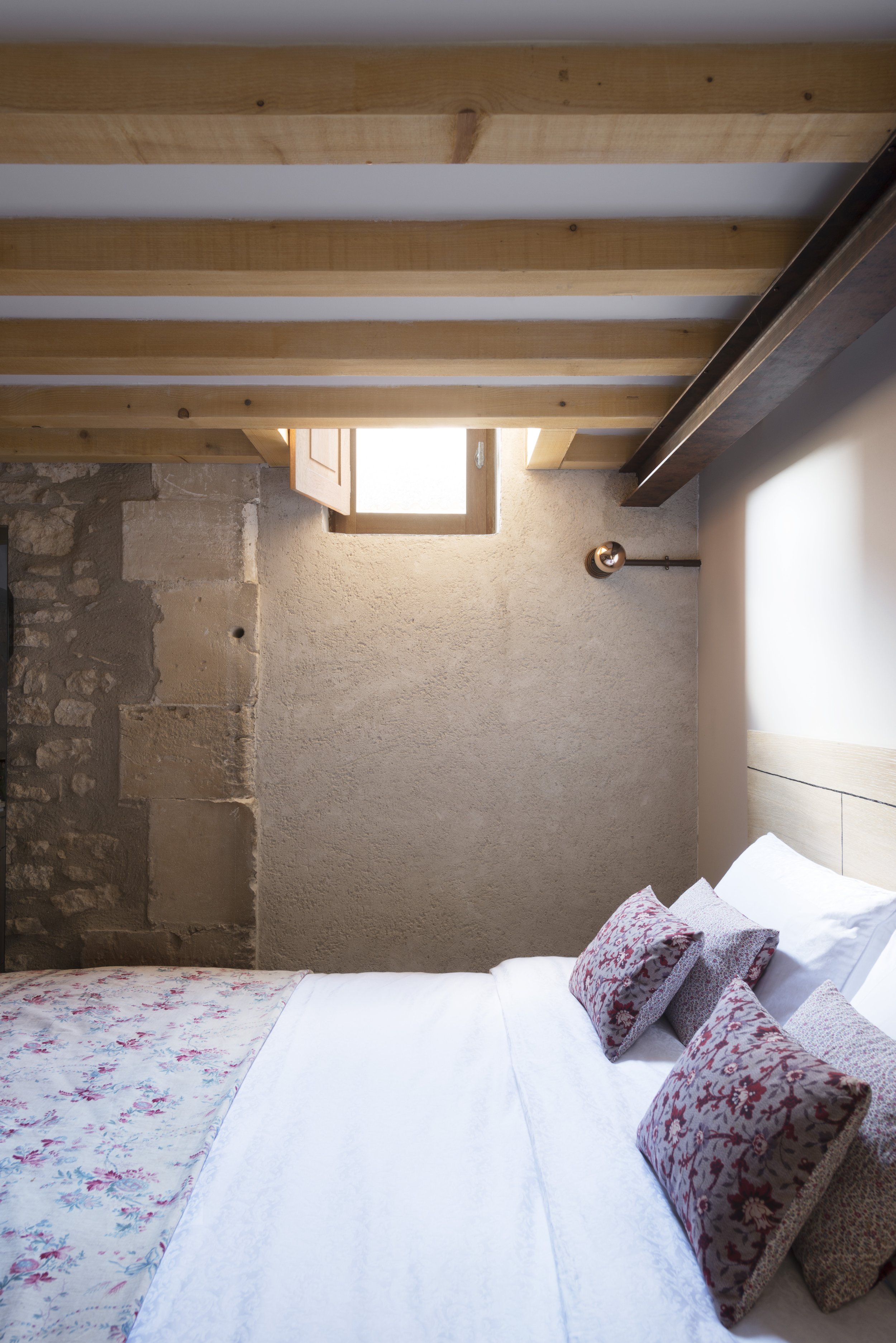 Detail of the bed in the principal bedroom, with a bedcover and cushions made from locally sourced vintage textiles.
