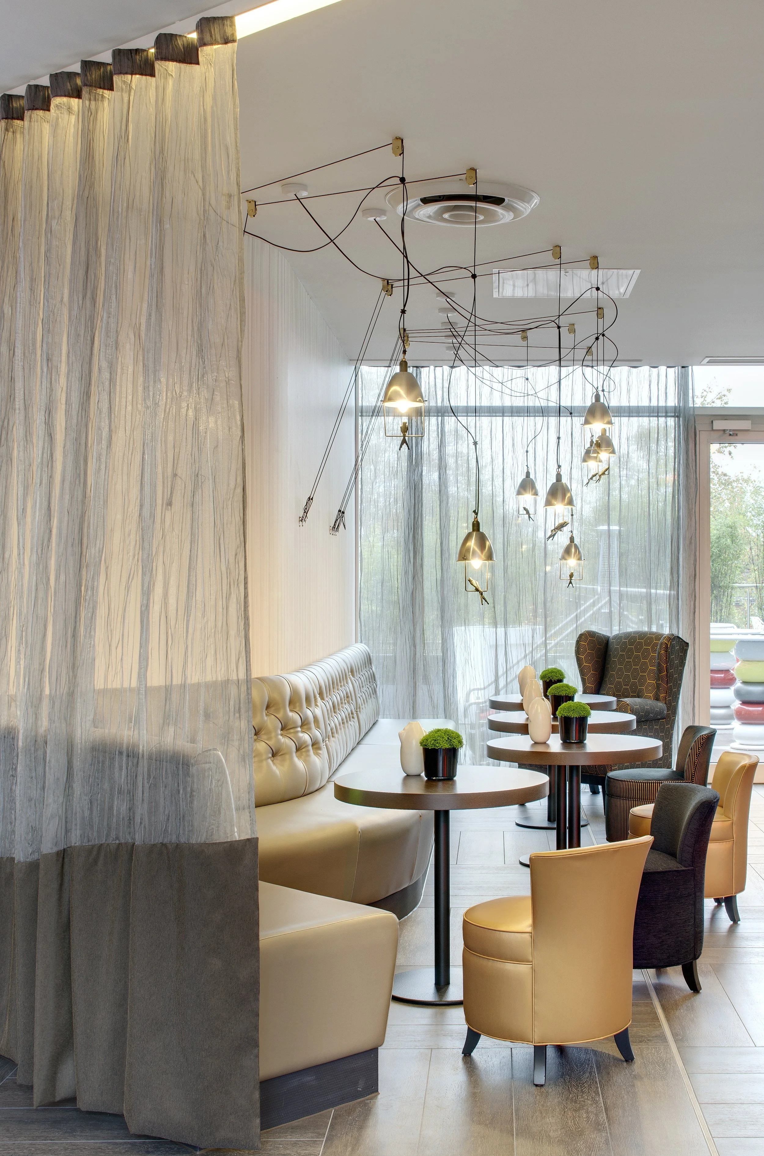 Detail of one side of the lobby with buttoned upholstery on the banquette, and lovely Pascal Stools by Rabih Hage.