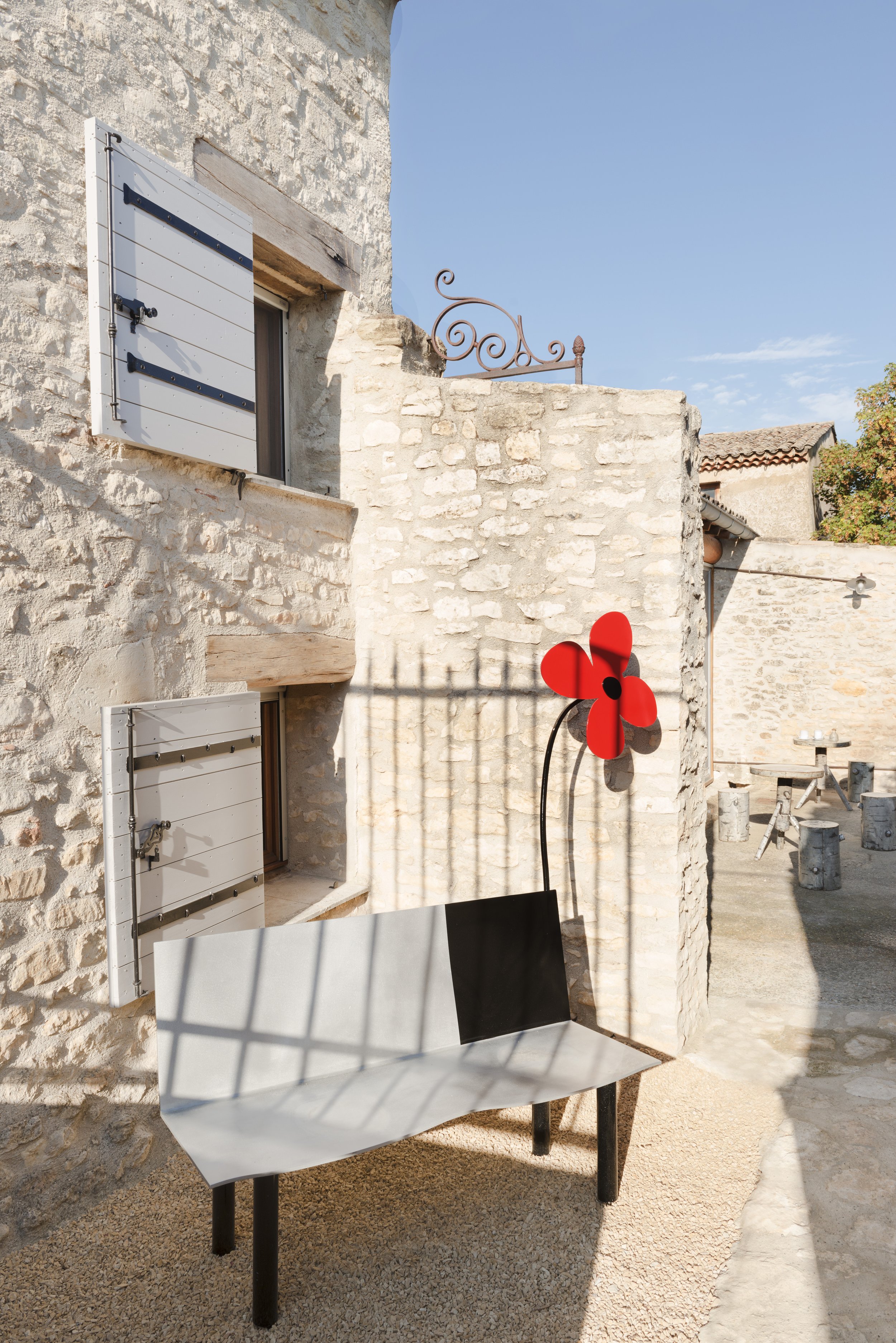 View of a partitioned area off the side of the courtyard with a sculptural 'Flower Bench' by Aki Kuroda.