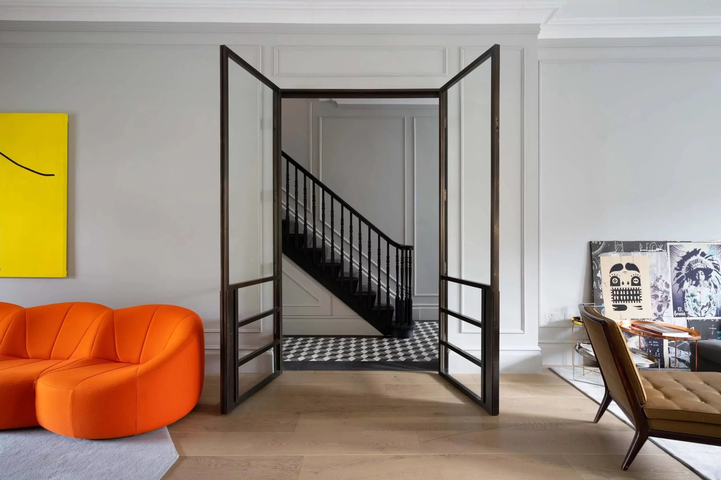 Interior image with elegant wall panelling and a bespoke glass and bronze door.