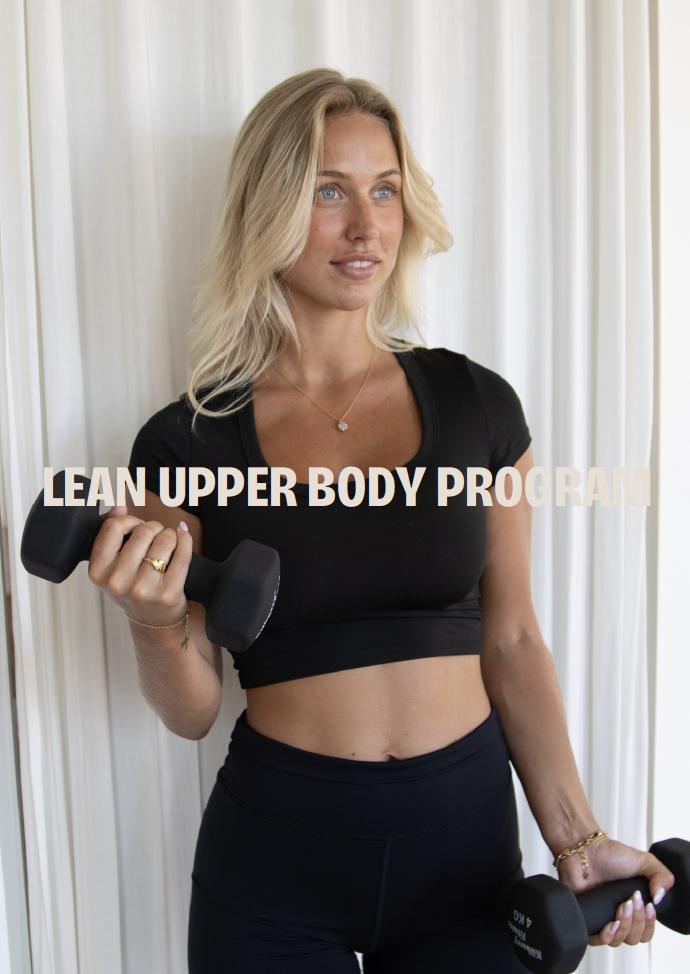 Kvinde i sort træningstøj holder håndvægte, med tekst "Lean Upper Body Program" på billedet, foran hvide gardiner.