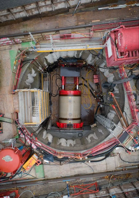 Overhead view of industrial construction site with large cylindrical machinery and scaffolding.