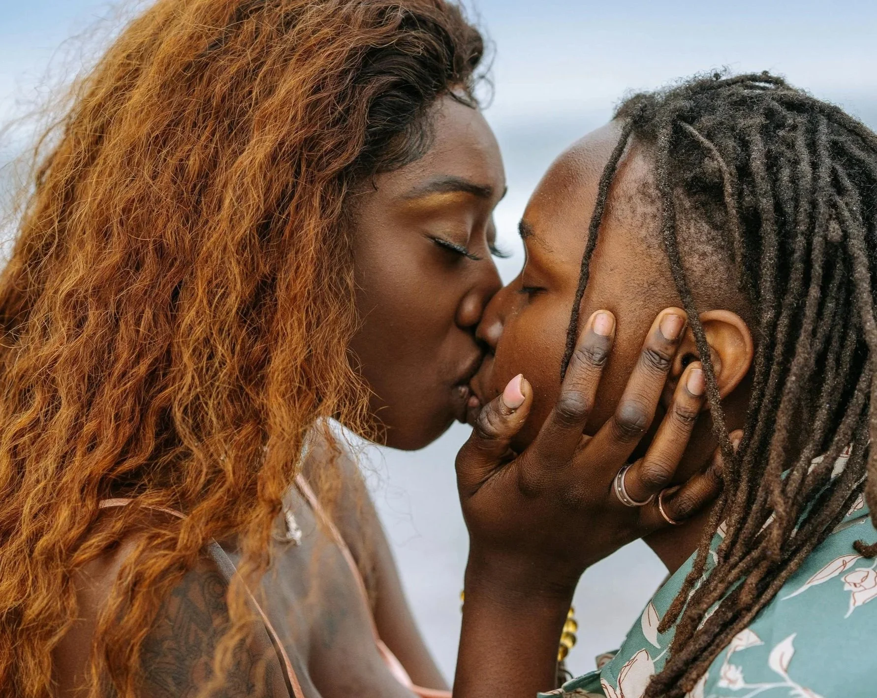 Two queer Black folks dating or in a relationship locked in a kiss