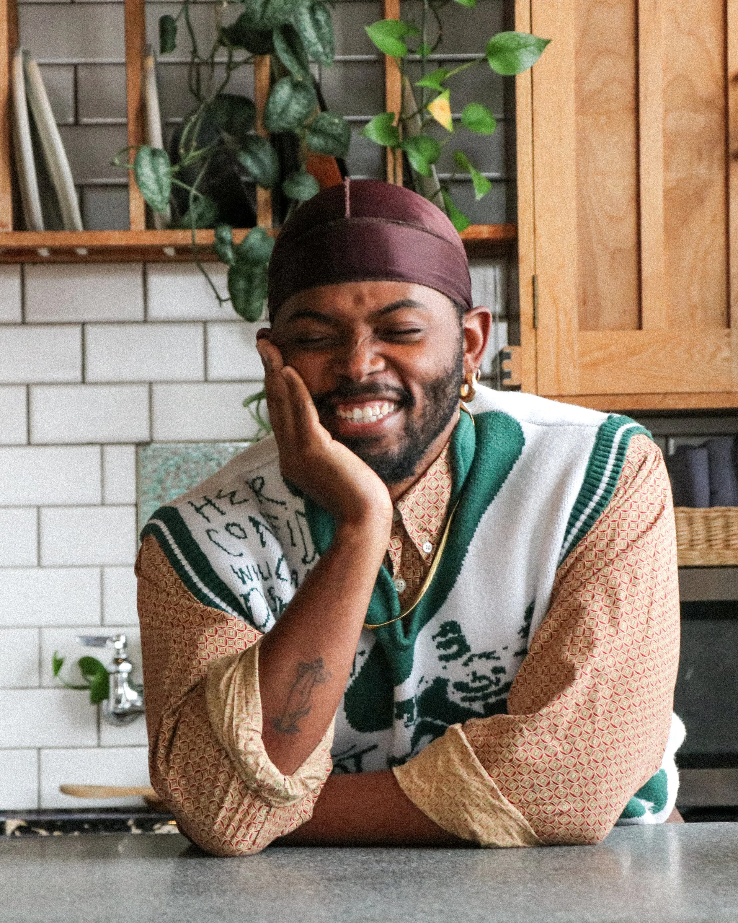 Keanu Jackson LCSW sits at a kitchen counter smiling
