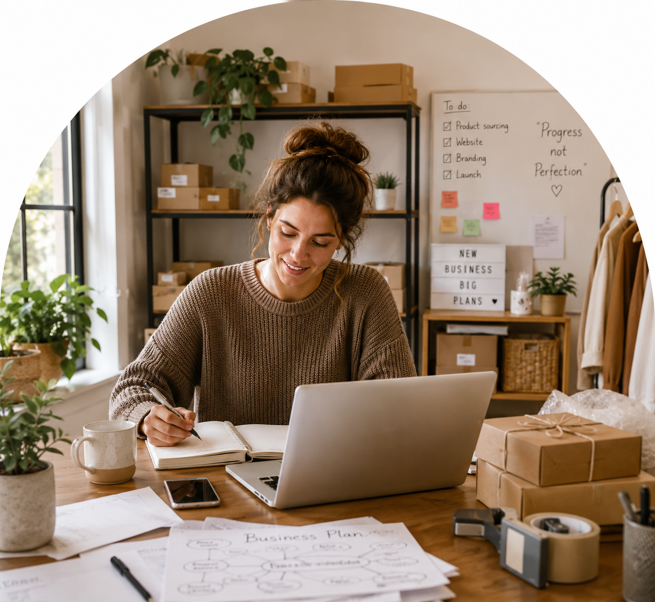 Small business owner working at a desk with a laptop and notebook