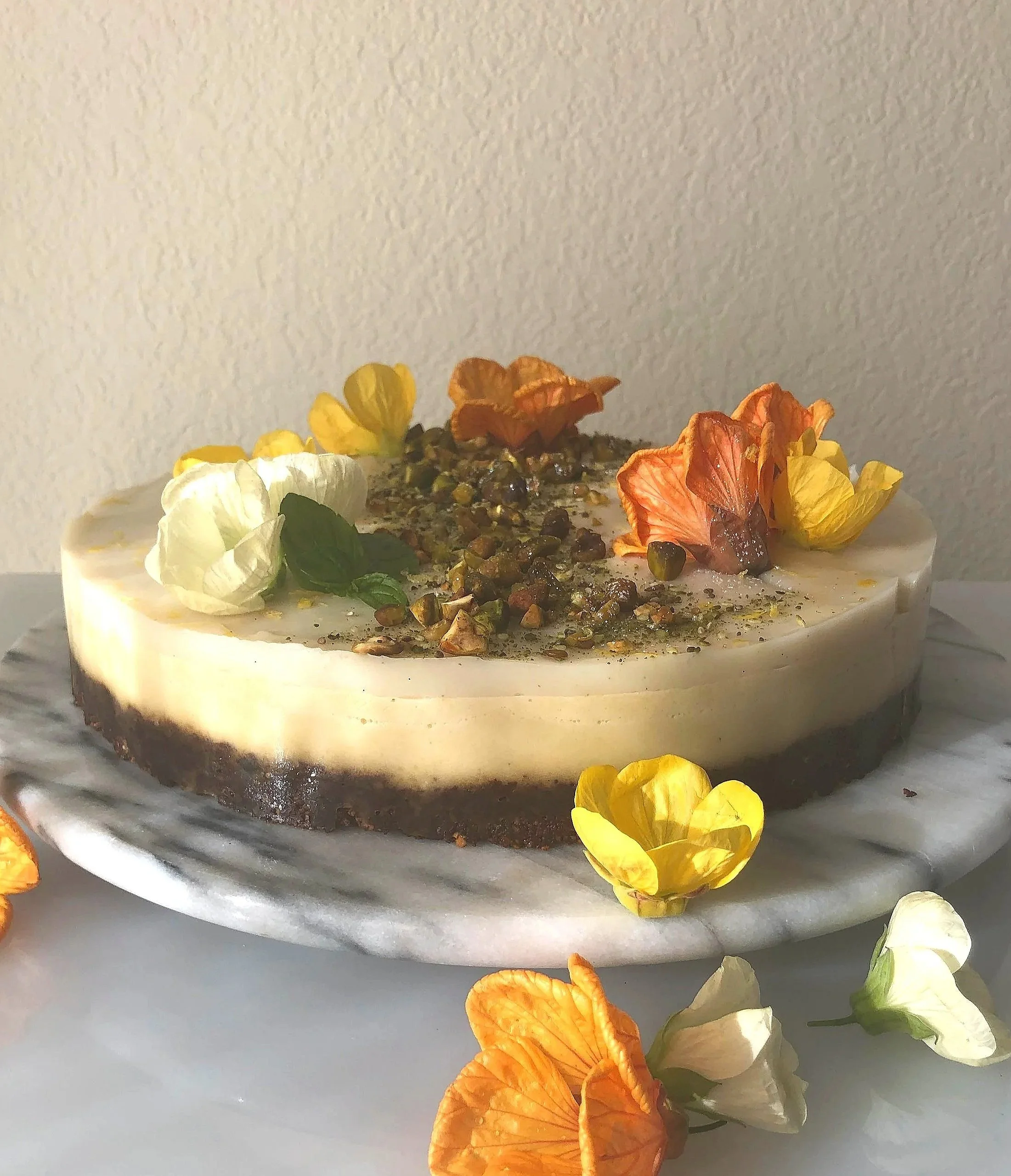 Nō 20 ------- CREAM LAKE CAKE - vegan-edible hibiscus blossoms.
layers of mango, lemon vanilla bean, dates, cashews, pistachios and more!

serves 8 - 12
$150