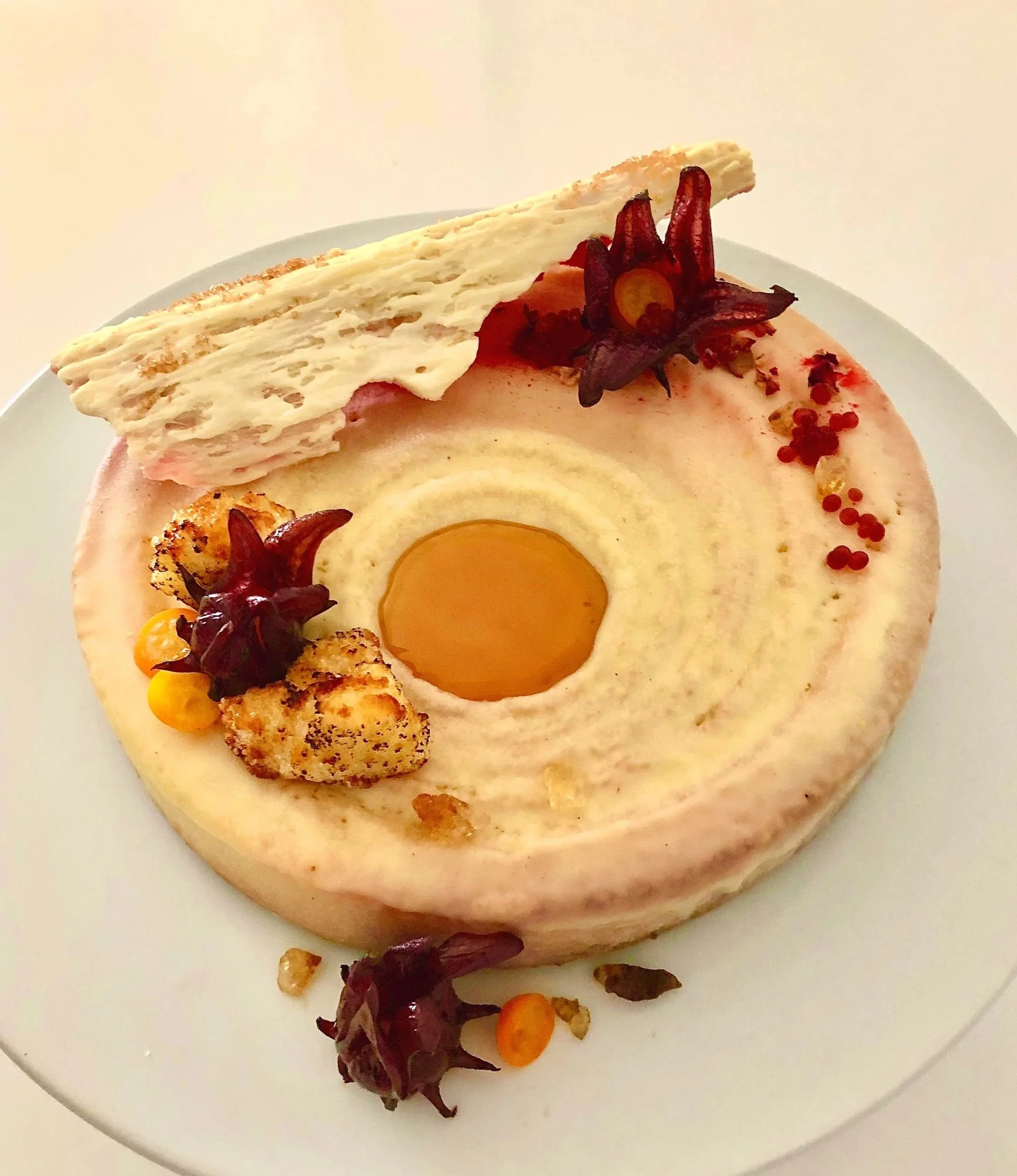 Nō 40 -------- DESERT TERRAIN CAKE - Olive oil cake filled with lemon white chocolate mousse
sprayed with white chocolate. Red belly and White chocolate bark sprinkled with Lemon Sugar.
Wild Hibiscus Flowers preserved in syrup. Mini slices of fresh K