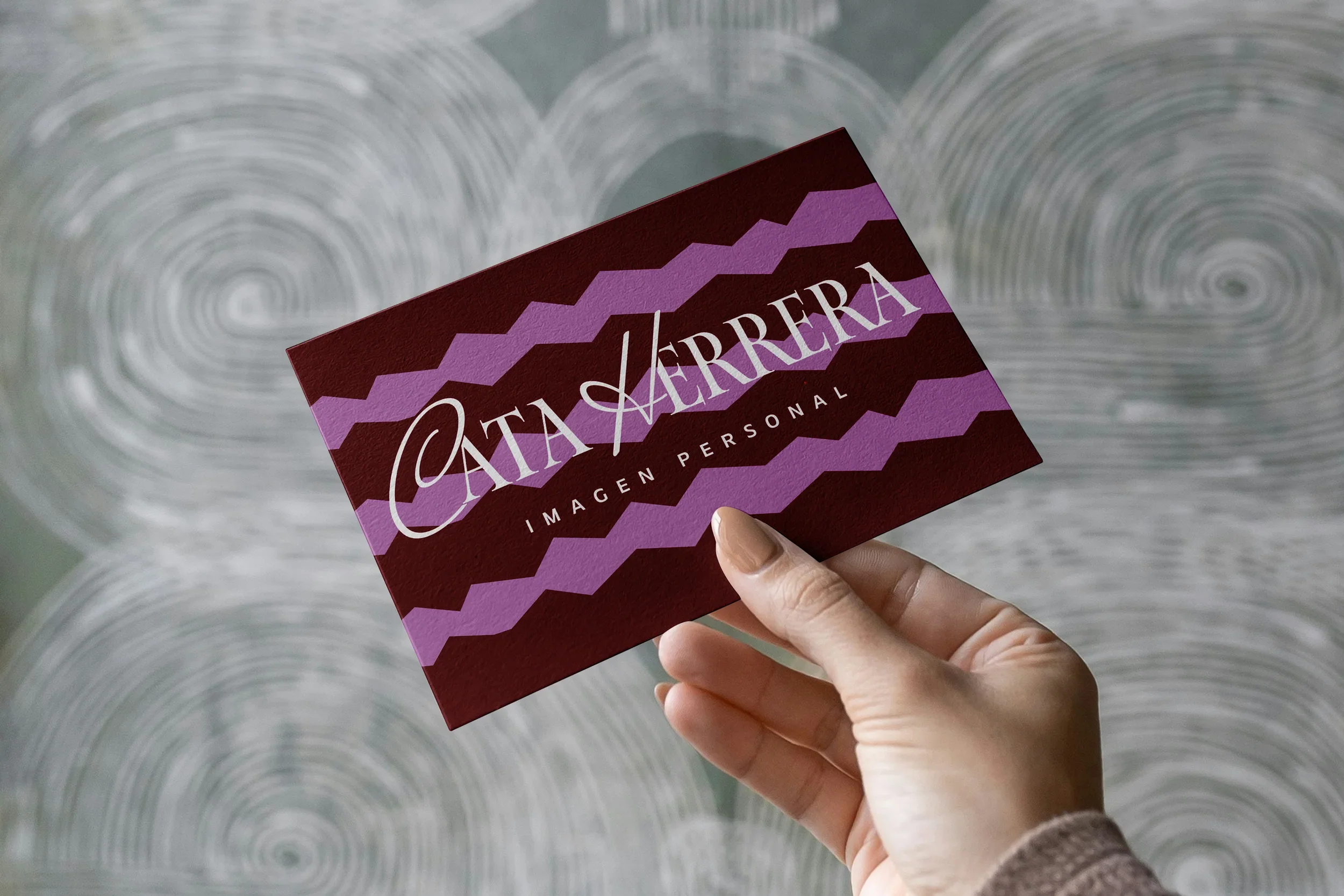 Tarjeta de Cata Herrera Imagen Personal con ondas lila sobre fondo vinotinto