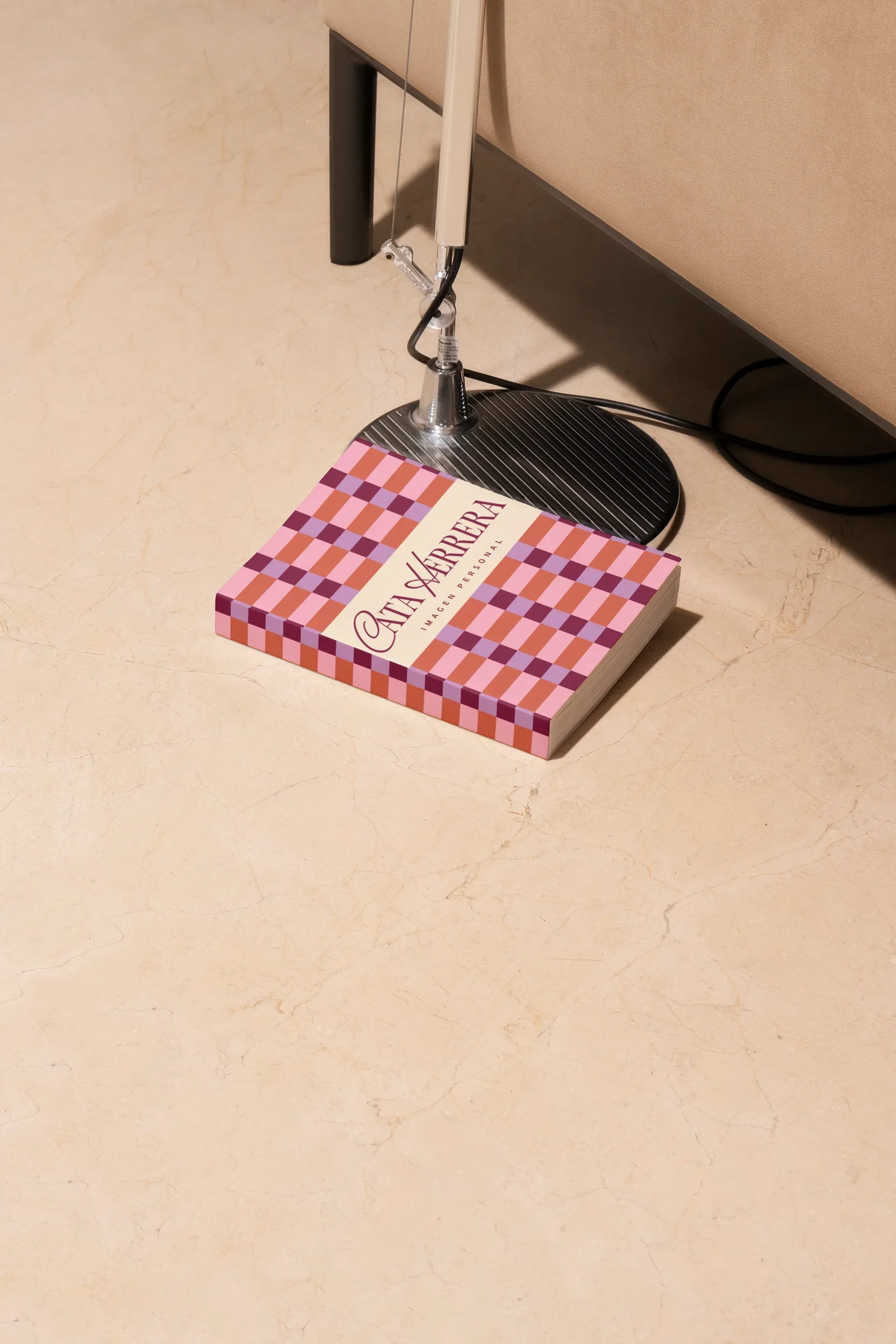 Cata Herrera book with a checkered cover on a marble floor