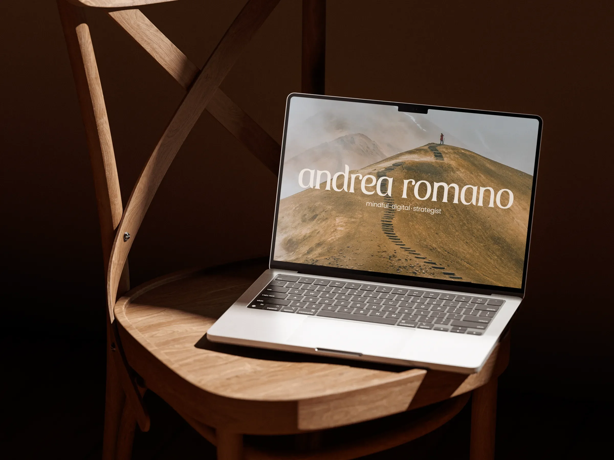 Sitio de Andrea Romano en una laptop sobre una silla