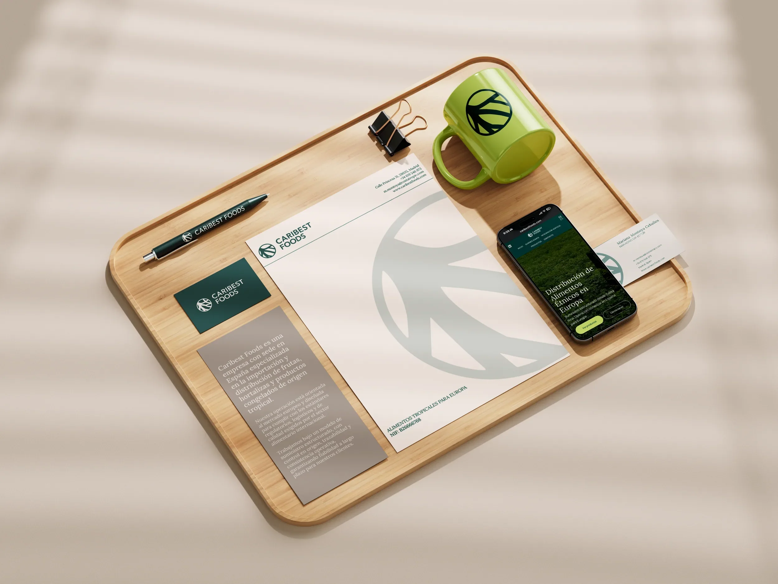 Papelería de Caribest Foods con taza, tarjetas y celular sobre una bandeja de madera