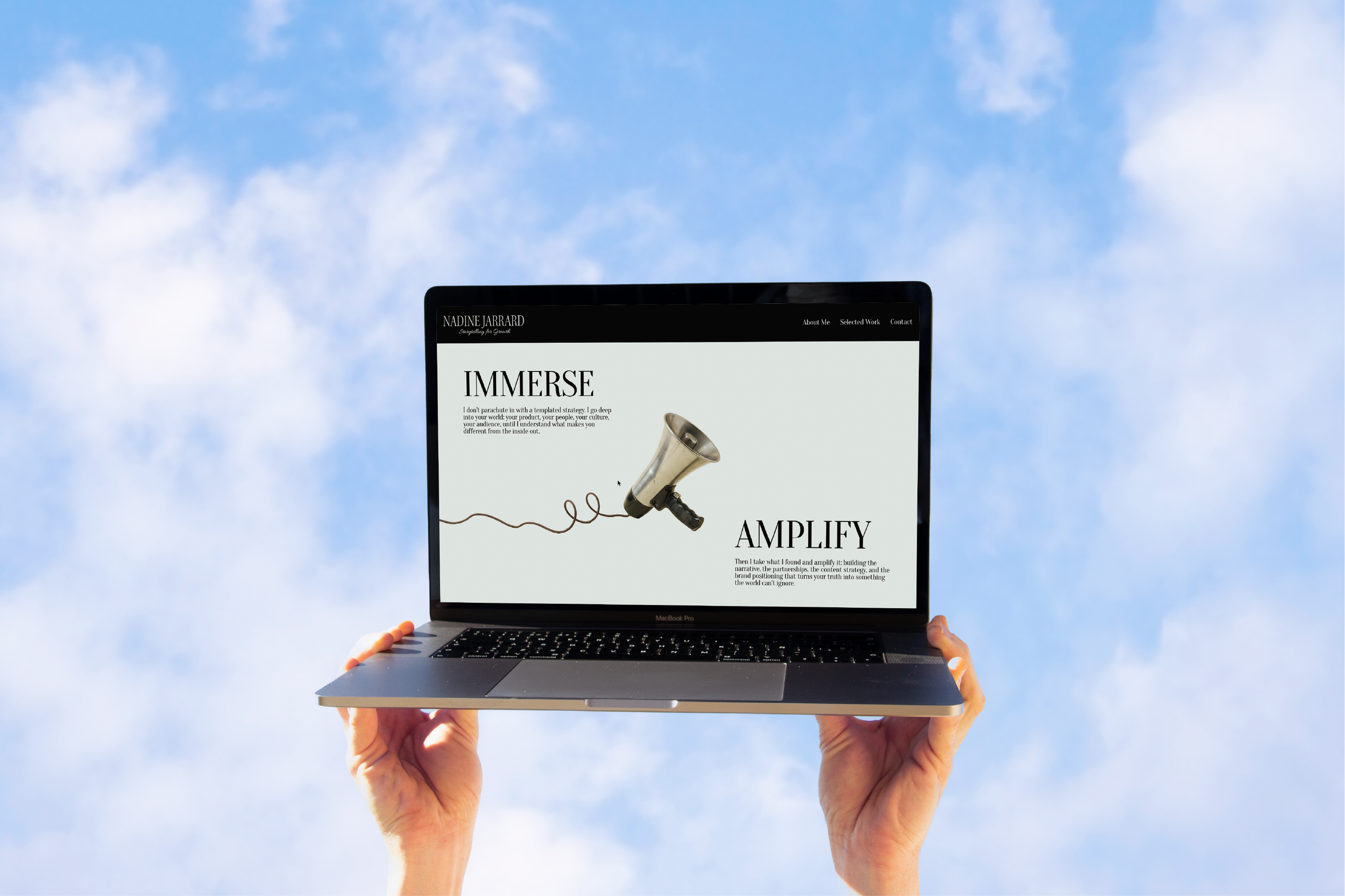 Laptop with Nadine Jarrard's website held up against the sky