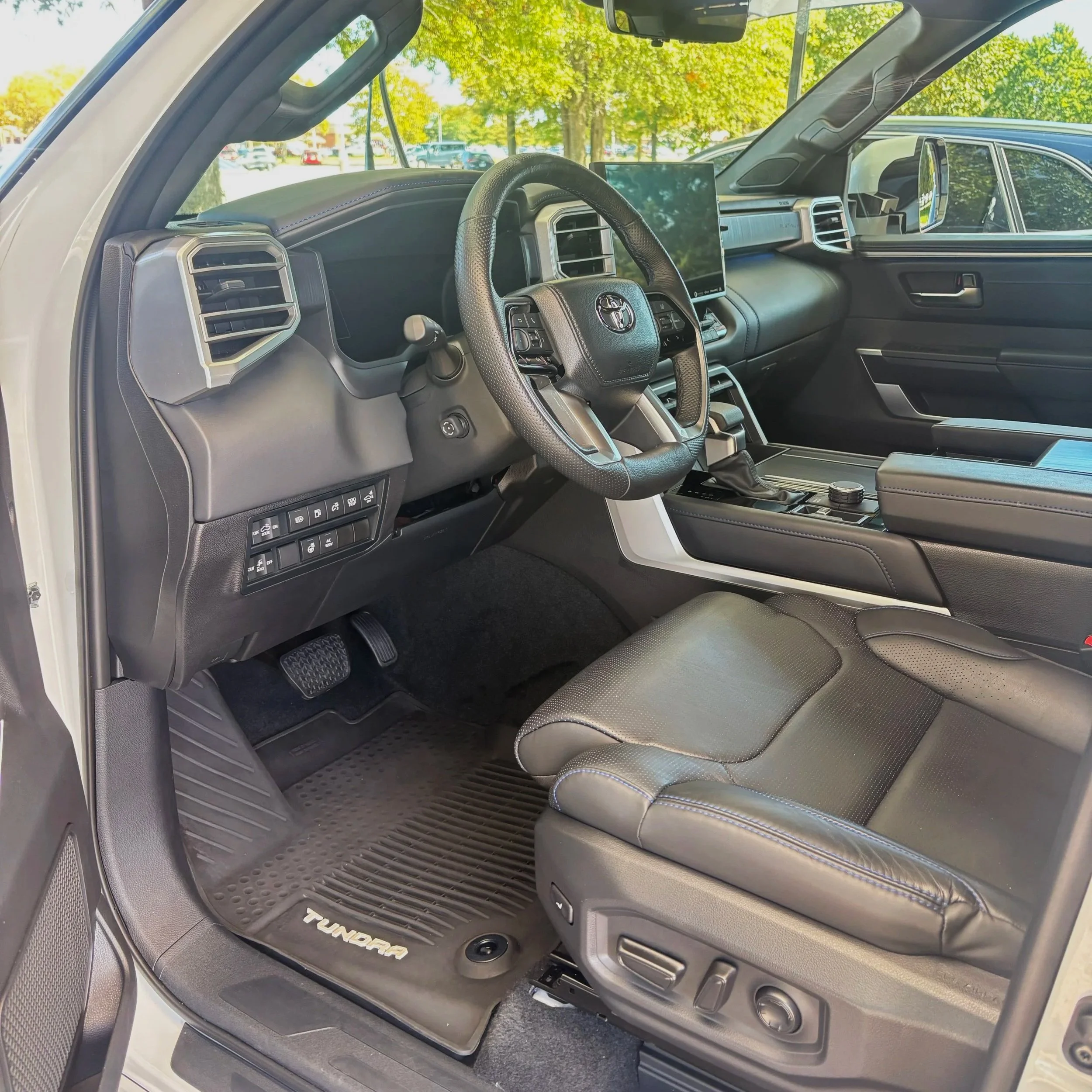Interior of a Toyota Tundra truck showcasing the driver's seat, steering wheel, dashboard, center console, and a large touchscreen display.