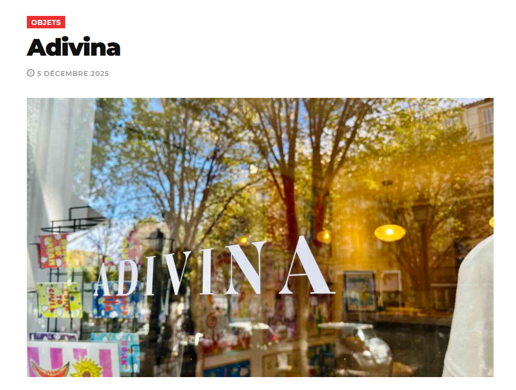 Vitrine d'une boutique avec le nom "Adivina" écrite sur la vitre, reflet des arbres et de la rue extérieure.