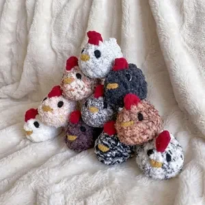 Collection of plush chicken toys in various colors and patterns arranged on a soft surface.