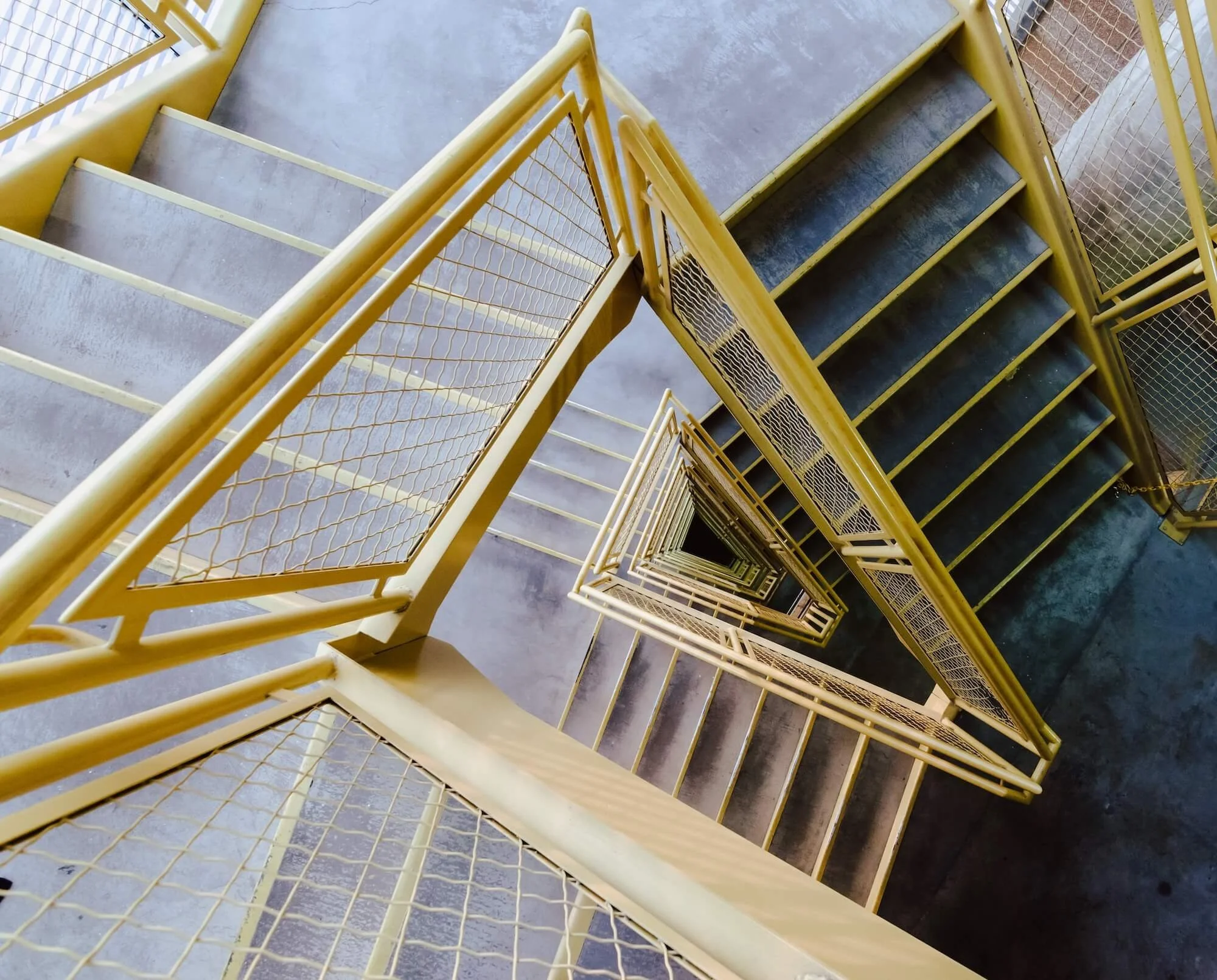 high-angle-shot-of-a-stairway-with-yellow-railings-2023-11-27-05-09-10-utc.jpeg