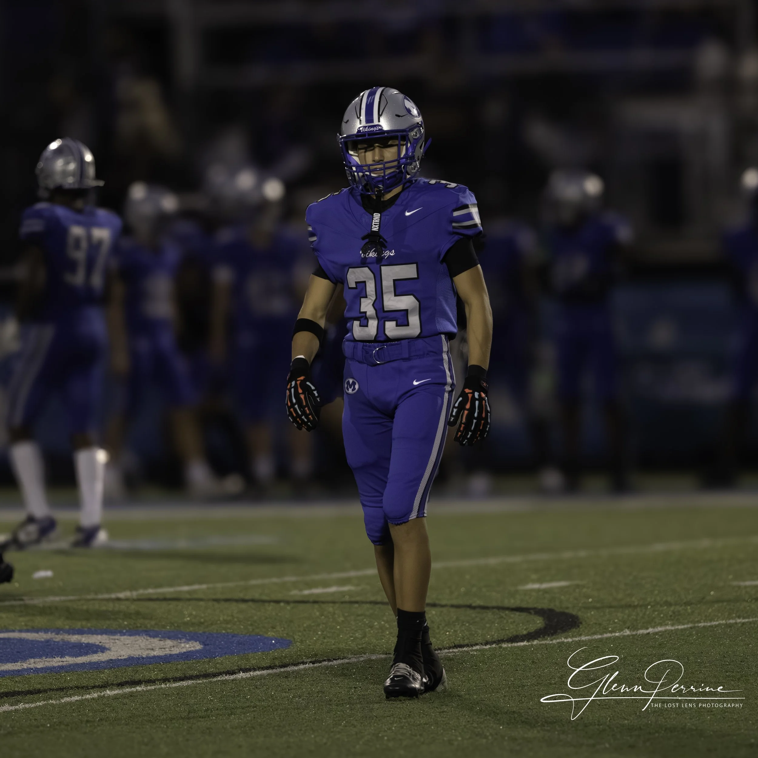 A football player in a blue uniform with the number 35 standing on a football field during a game.