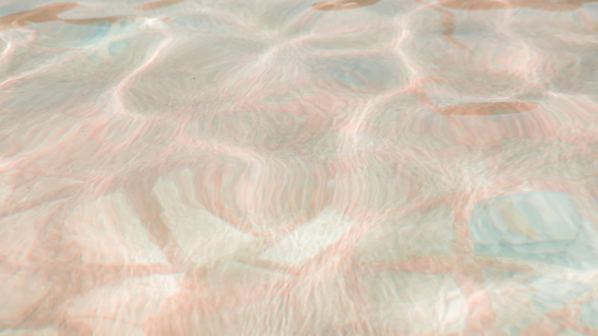 Close-up of clear water with gentle ripples and a hint of a sandy bottom.