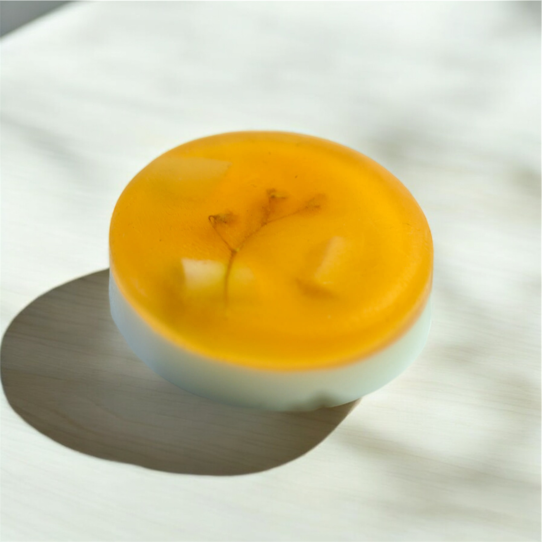 Savon rond avec inclusions, couleur orange sur le dessus.
