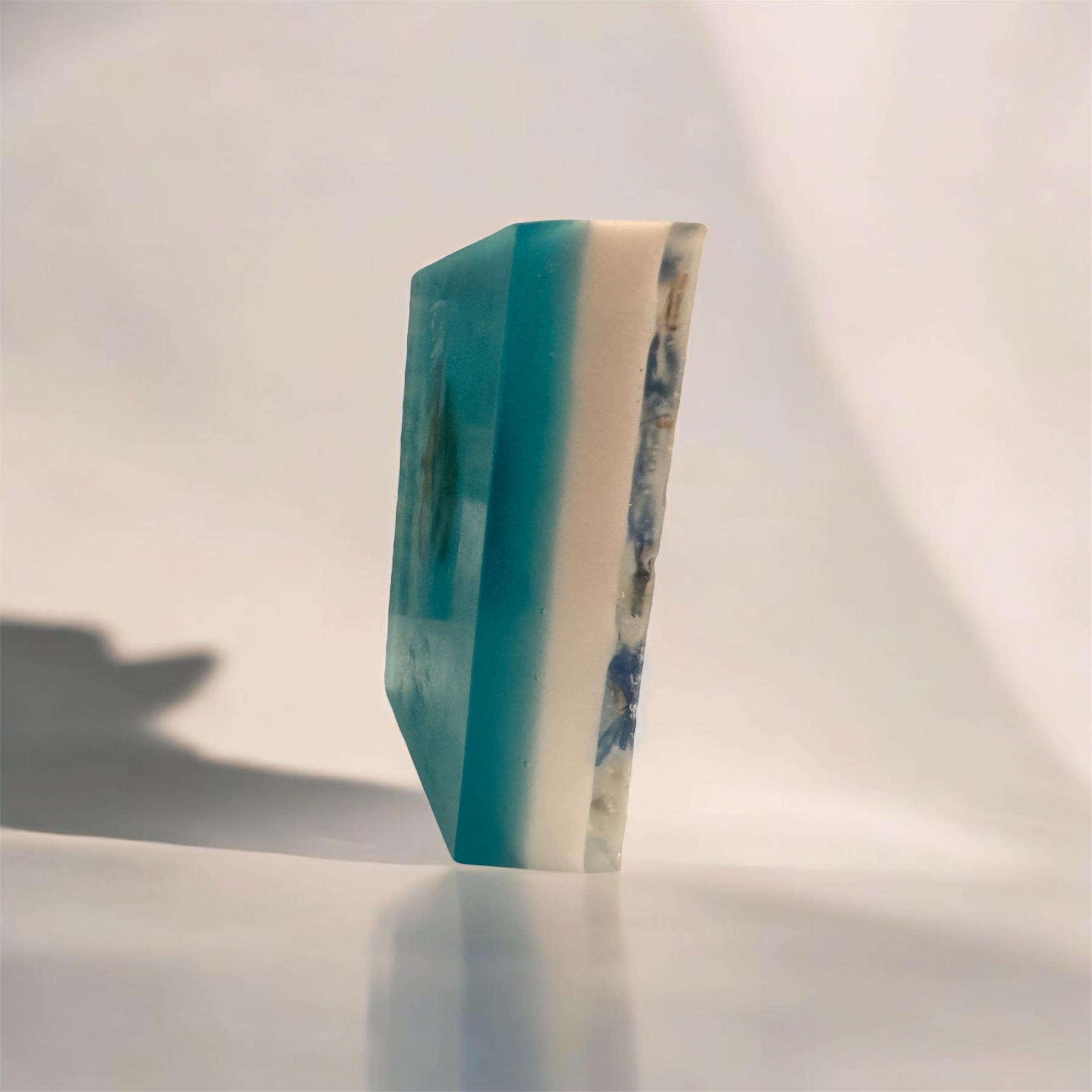 Savon artisanal en tranches bleu et blanc sur fond beige.