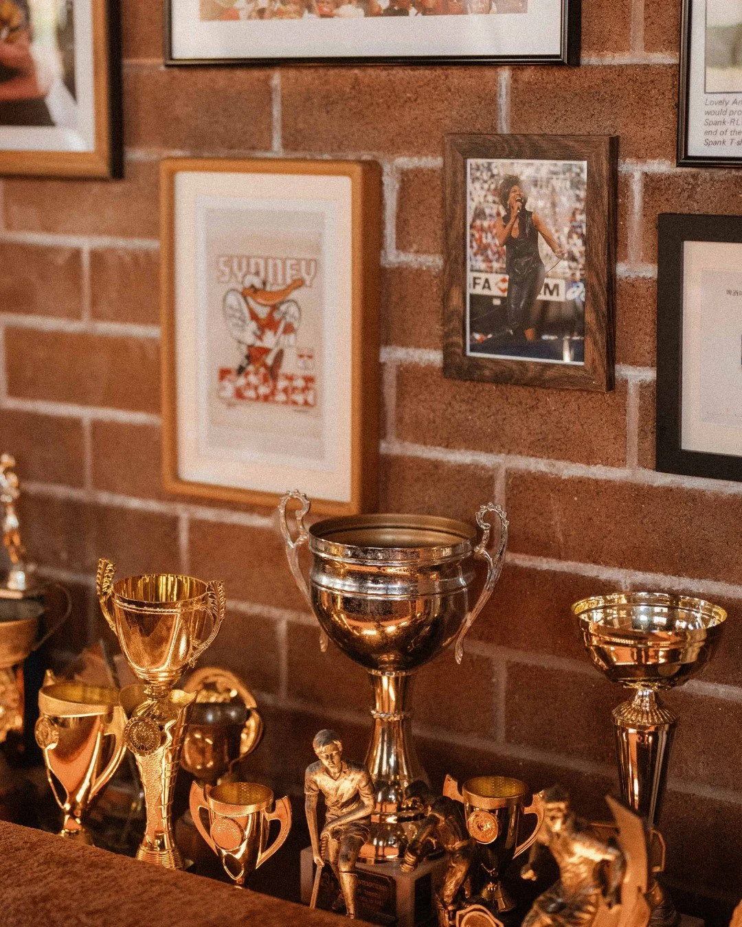 Trophies, old photos, framed footy legends - like your uncle's garage... just with better drinks 🍸