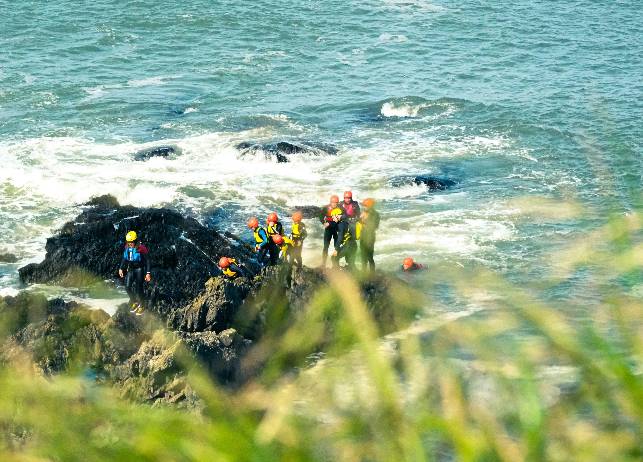 A group of Educamps adventures kids on the south coast expedition, jumping into the waves of the jurassic coast, supervised by qualified instructors