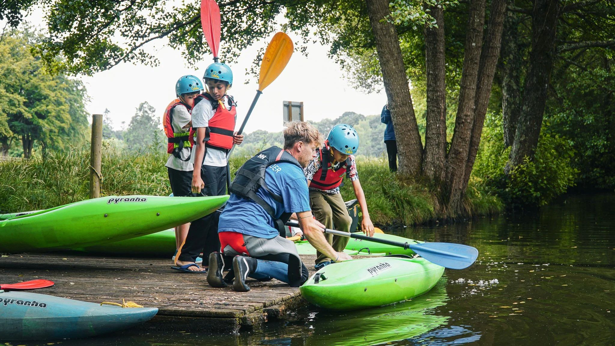 Qualified activity instructor delivering a safety briefing at summer camp.