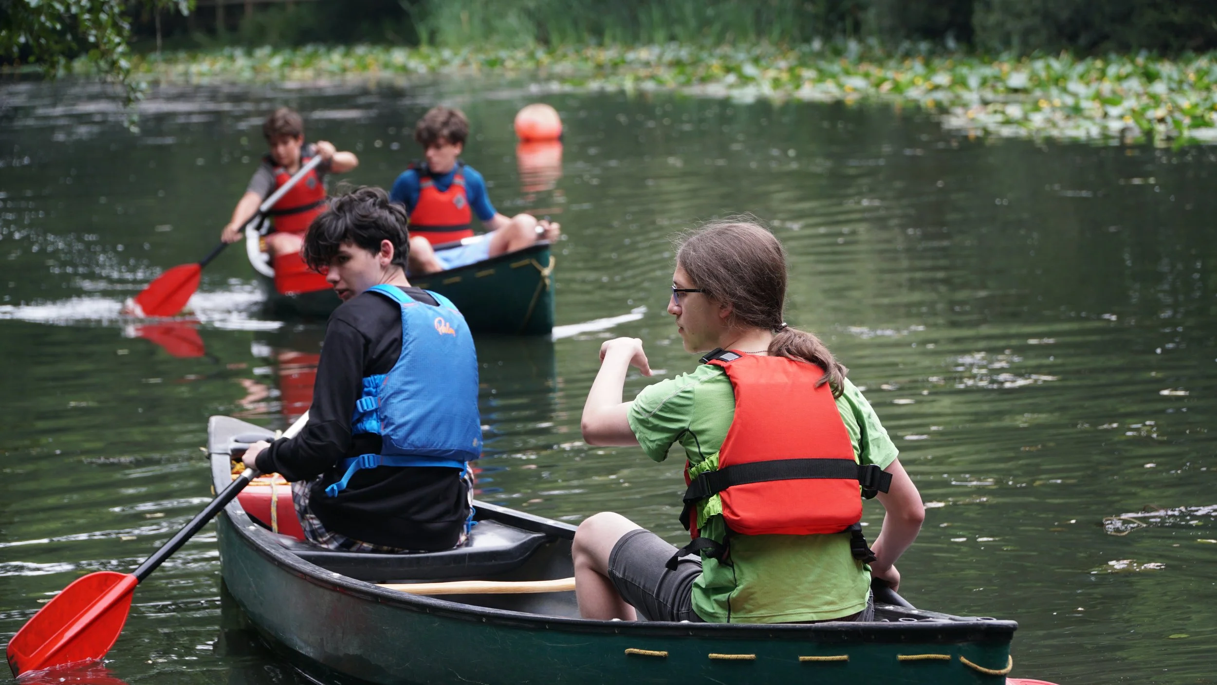 international students on our adventure only camp canoeing on our on site lake