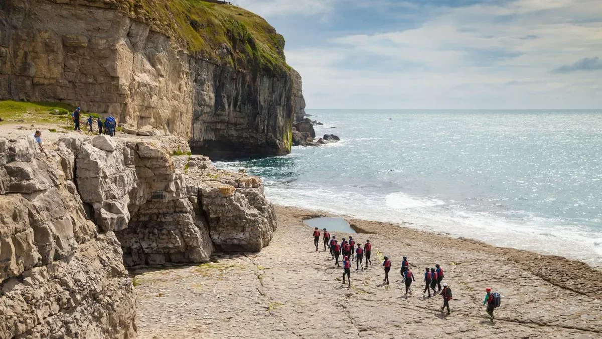A photo of teens coasteering at Dancing Ledge on a South Coast Expedition Camp