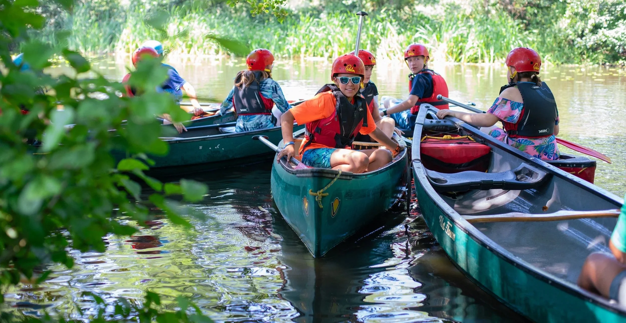 Children taking part in a canoeing activity on the lake, during a New Forest Summer Camp