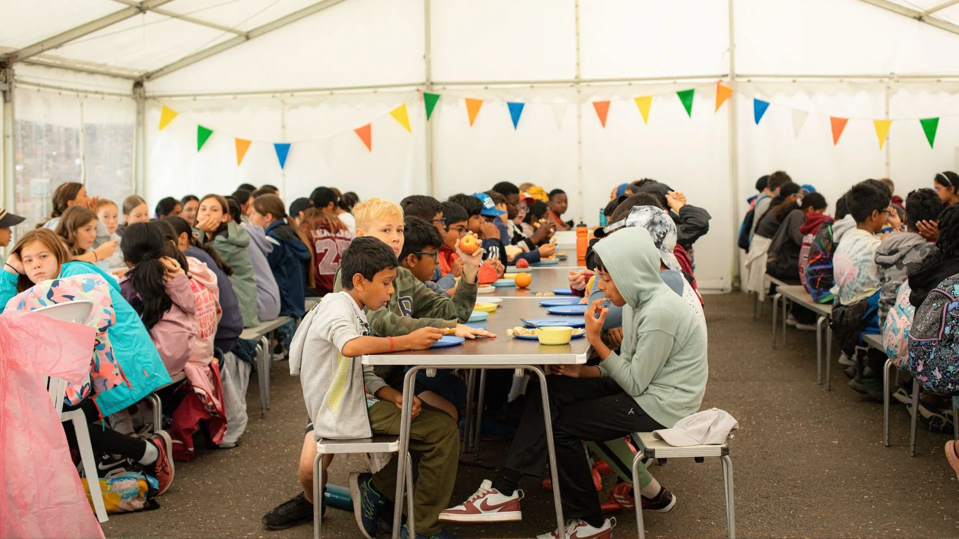 Children enjoying a supervised mealtime at a UK summer camp