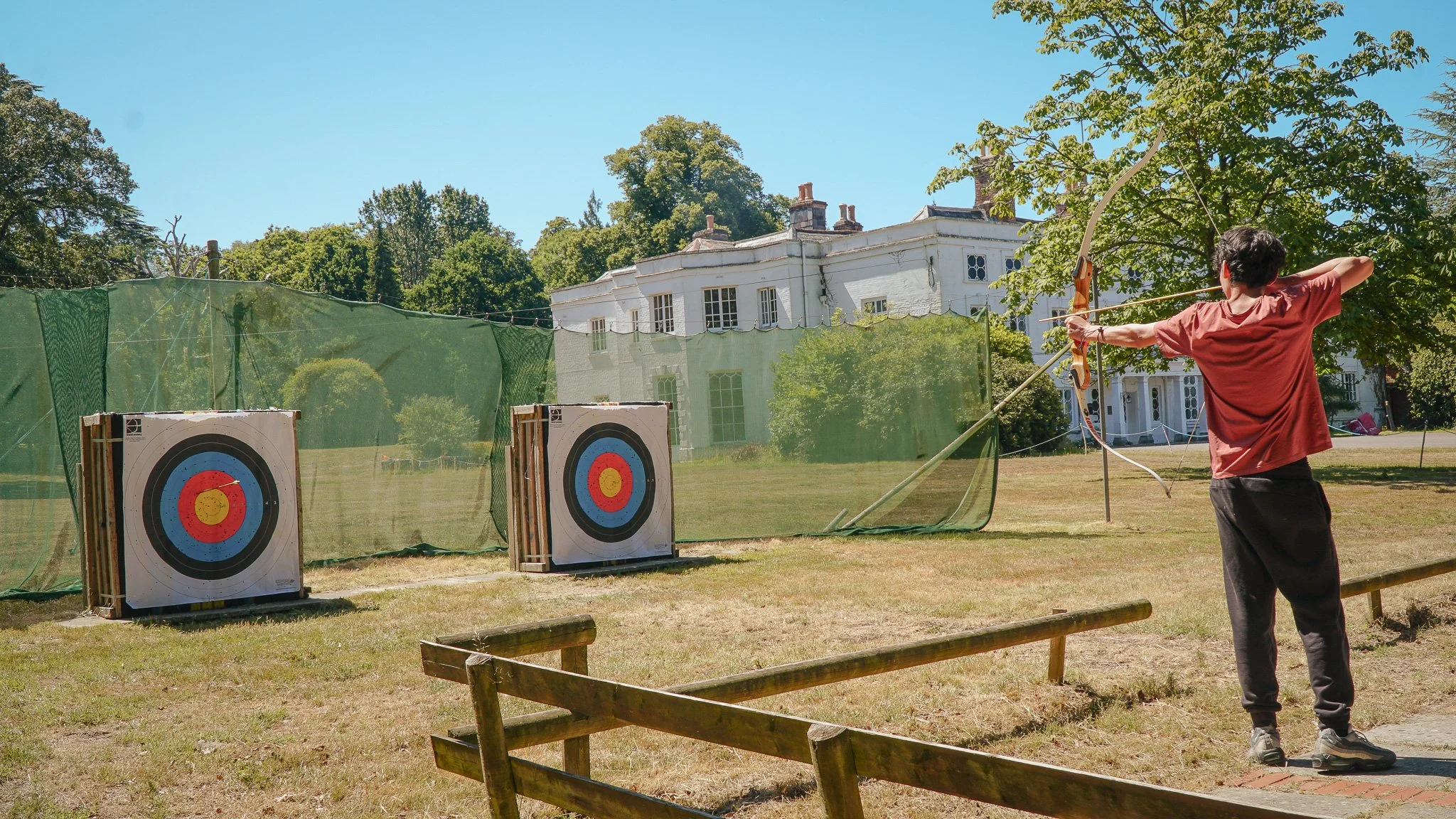 an international Ukraine student doing archery on site at our new forest adventure camp