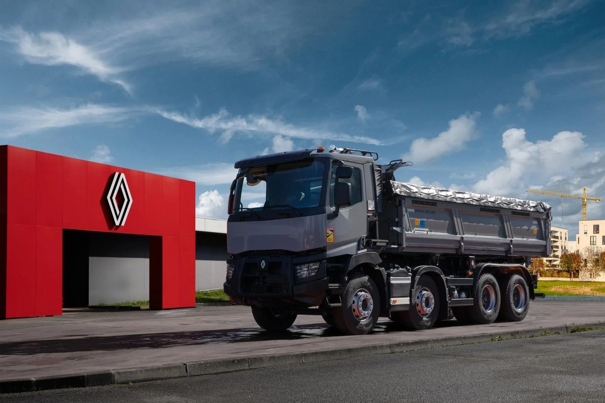 Renault Trucks C Baustellen-Lkw vor einem roten Lagerhaus, robuster Schwerlast-Lkw für Baugewerbe, Baustellenlogistik und anspruchsvolle Transporte mit markanter Präsenz.