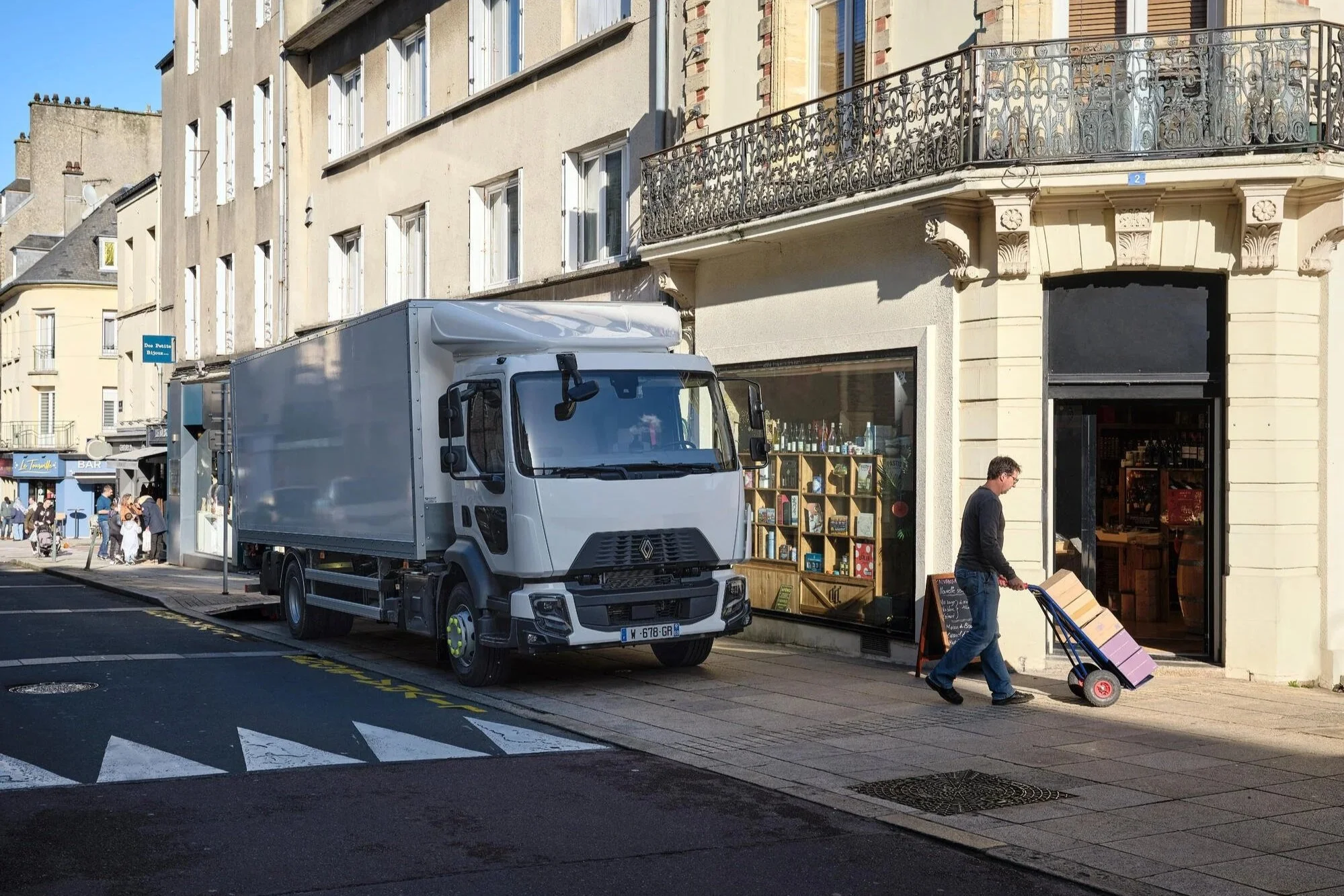 Renault Trucks D Diesel Verteiler-Lkw in einer urbanen Straße während der Paketzustellung, effiziente Transportlösung für Lieferverkehr, City-Logistik und regionale Distribution.