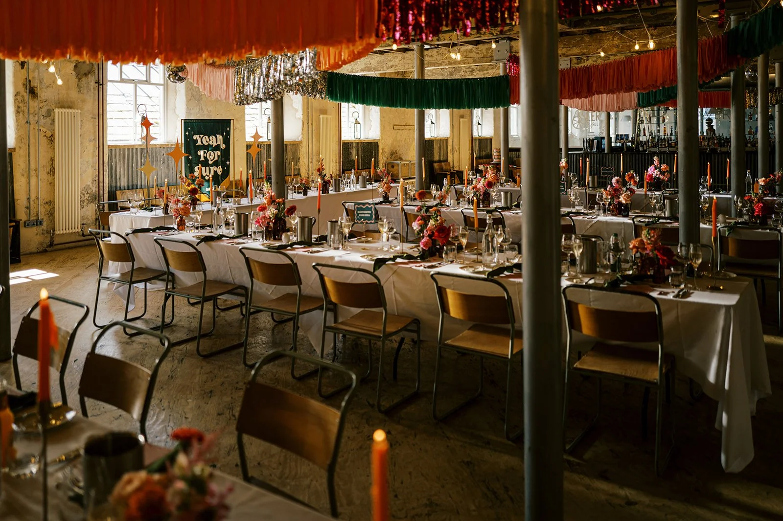 colourful tablescape under colourful streamers in a industrial vibe room